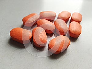 Medicine tablet in Orange colour on white table