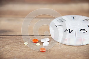 Medicine tablet in pillbox on wood table