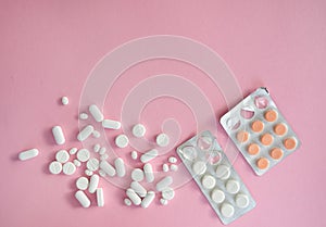 medicine tablets antibiotic pills on a pink background, cold and disease treatment