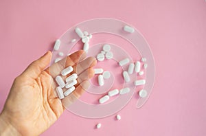 medicine tablets antibiotic pills on a pink background, cold and disease treatment