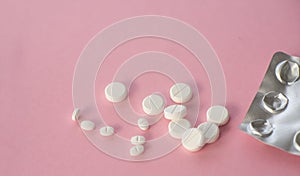 medicine tablets antibiotic pills on a pink background, cold and disease treatment