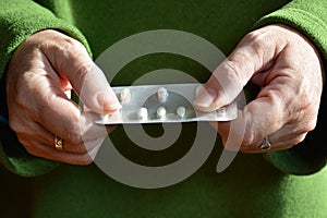 Medicine time. Woman holding a blister pack of white tablets