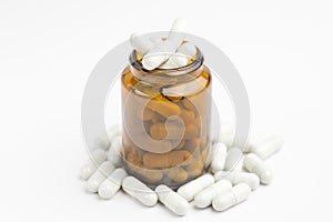 Medicine white pills or tablets drop out of the brown glass bottle