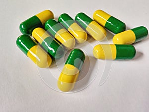 Medicine with yellow and green color againts white background