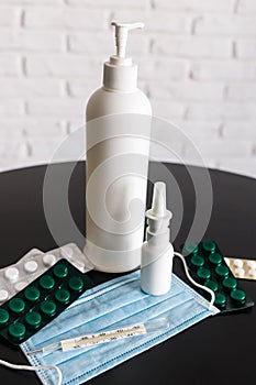 Medicines, medicines, antiseptic, thermometer, virus protective mask on a black table