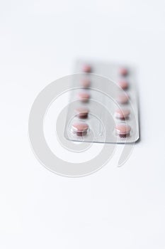 Medicines and pills. Multicolored medicines on a white background close-up. Plate with pink pills on a white background