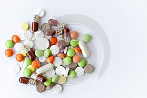 Medicines and pills. Multicolored medicines on a white background close-up. A slide of colored tablets on a white