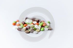 Medicines and pills. Multicolored medicines on a white background close-up. A slide of colored tablets on a white