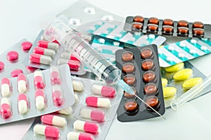 Medicines and syringe on white background