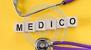 MEDICO text made in building wood blocks on yellow desk