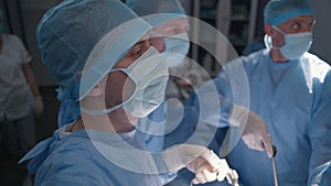 Medics operate patient and look at monitors in operating room