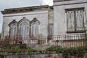 Medieval abandoned house with closed windows and weathered walls. Old cottage with grunge facade.