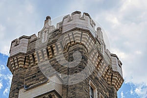 Medieval ages style tower top of a castle against the blue cloudy sky