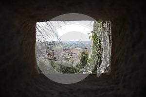 Medieval ancient rock slit window from which you can see the view over the pietrasanta valley
