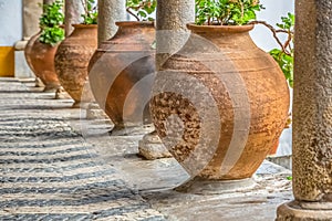 Medieval arcade view with orange ceramic vases and antique granite columns in Obidos