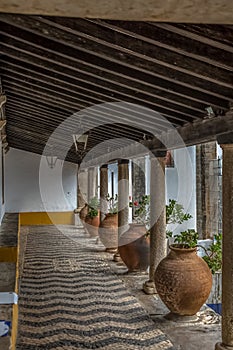 Medieval arcade view with orange ceramic vases and antique granite columns in Obidos