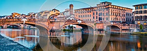 Medieval arched river bridge with Roman origins - Ponte Santa Trinita over Arno river. Panoramic summer cityscape of Florence, Ita photo
