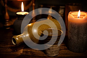 Medieval background with a old bottle, a mug and candles