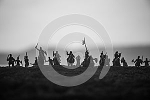 Medieval battle scene with cavalry and infantry. Silhouettes of figures as separate objects, fight between warriors on sunset