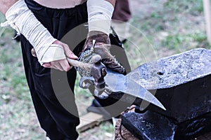 Medieval Blacksmith Crafting an Axe on Anvil with Hammer in Nature