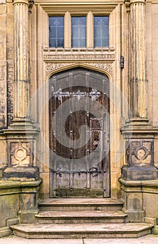 A medieval brown wooden door with columns.