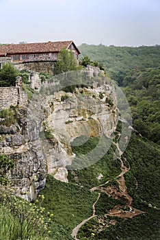 Medieval building on a high cliff above the mountain valley in the famous ancient city-fortress of Chufut-Kale