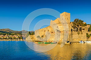 Medieval castle and boats at Collioure city at sunrise in France