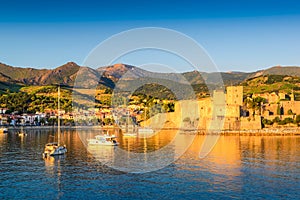 Medieval castle and boats at Collioure city at sunrise in France