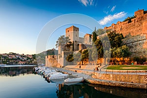 Medieval castle and boats at Collioure city at sunrise in France