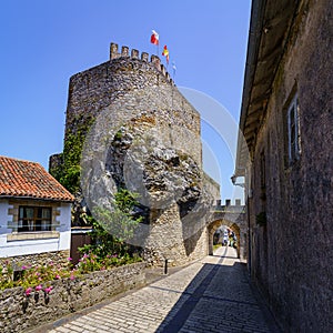 Medieval castle with narrow lane and entrance arch under the wall. San Vicente de la Barquera