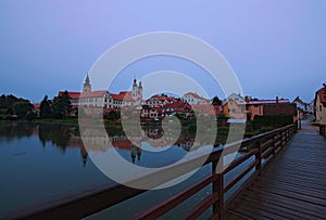 Medieval castle and old town with beautiful mirror reflections on smooth lake water. Summer landscape