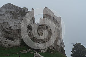 Medieval castle ruin sitting on top of hill in heavy fog