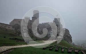 Medieval castle ruin sitting on top of hill in heavy fog