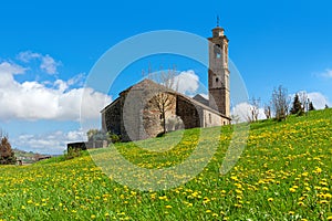 Medieval church on spring field in Italy.