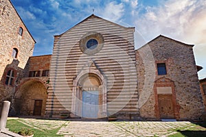 medieval church in the tuscan town of lucignano at sunset