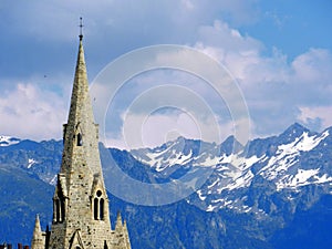 The medieval Collegiate Church of Saint-Andre tower on the background of snowy Alps, Grenoble