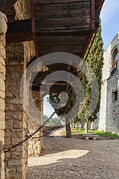 Medieval counterweight system used for the drawbridge at Brescia castle, framed by a stony arch and flanked by cypress trees