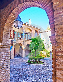 The medieval court of Casa de las Bulas through the arch, Cordoba, Spain photo