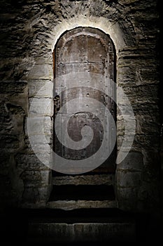 Medieval door close up. Ancient castle metal door fragment with stone steps. Dark, moody, scary concept