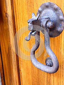 A medieval doorknocker on a wooden door in a Tuscan hill town Italy