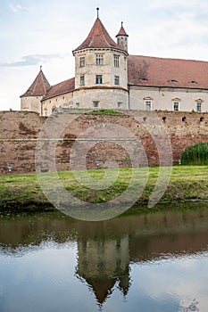 The medieval Fagaras Citadel, dating back to 1310, reflected in its castle moat. FagaraÈ™, Brasov County, Transylvania, Romania