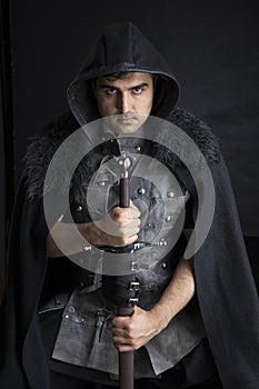 Medieval or fantasy character in leather jerkin and holding weapons