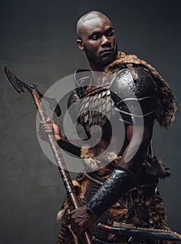 Medieval fighter dressed in protectrive antique clothing holding an axe