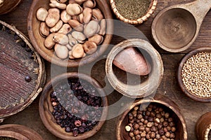 Medieval food in wooden and ceramic dinnerware. Cereals, seeds, dried berries, beans, salt and other foods