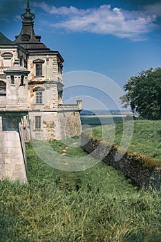 medieval fortress on a background of green lawn on a background of blue sky and fields in the distance.