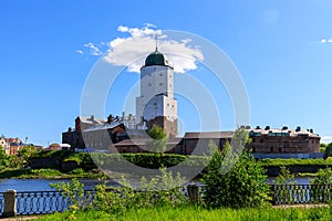 Medieval fortress in Vyborg. Castle on the water against the blue sky with clouds