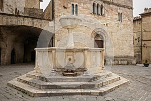 Medieval fountain and San Silvestro Church facade in the main square of the town of Bevagna in Umbria Italy.