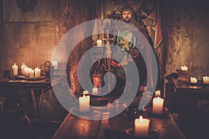 Medieval king on the throne in ancient castle interior.