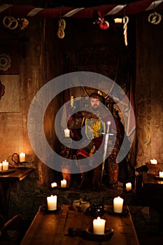 Medieval king on throne in ancient castle interior.