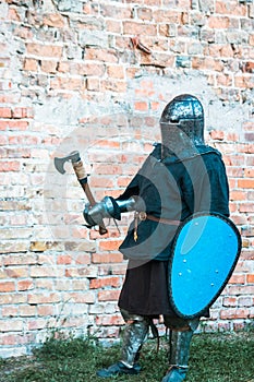 Medieval knight in armor with an ax and shield